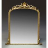 A large giltwood overmantle mirror, early 19th Century, of arched form with carved scrolling foliate