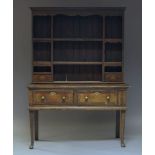 A George III oak Welsh dresser, the later plate rack with an arrangement of shelves and two drawers,