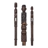 A tribal hardwood carved finial of a crouching man, possibly Luba, modelled with his hands in