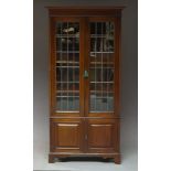 A mahogany bookcase, early 20th Century, the moulded cornice, above two glazed and leaded doors,