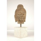 A Song dynasty style carved stone head of Buddha, 20th century, mounted on a square stone block, the