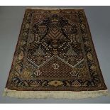 A Tehran silk rug, late 20th Century, the indigo field elaborately decorated with sprays of flowers,
