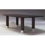 A large contemporary stained oak dining table, of recent manufacture, the shaped top, on cylindrical