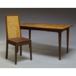 A teak extending dining table, c.1960, the curved rectangular top, with one pull out leaf beneath,