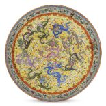 A Chinese porcelain 'nine dragons' dish, Republic period, painted in famille rose enamels with