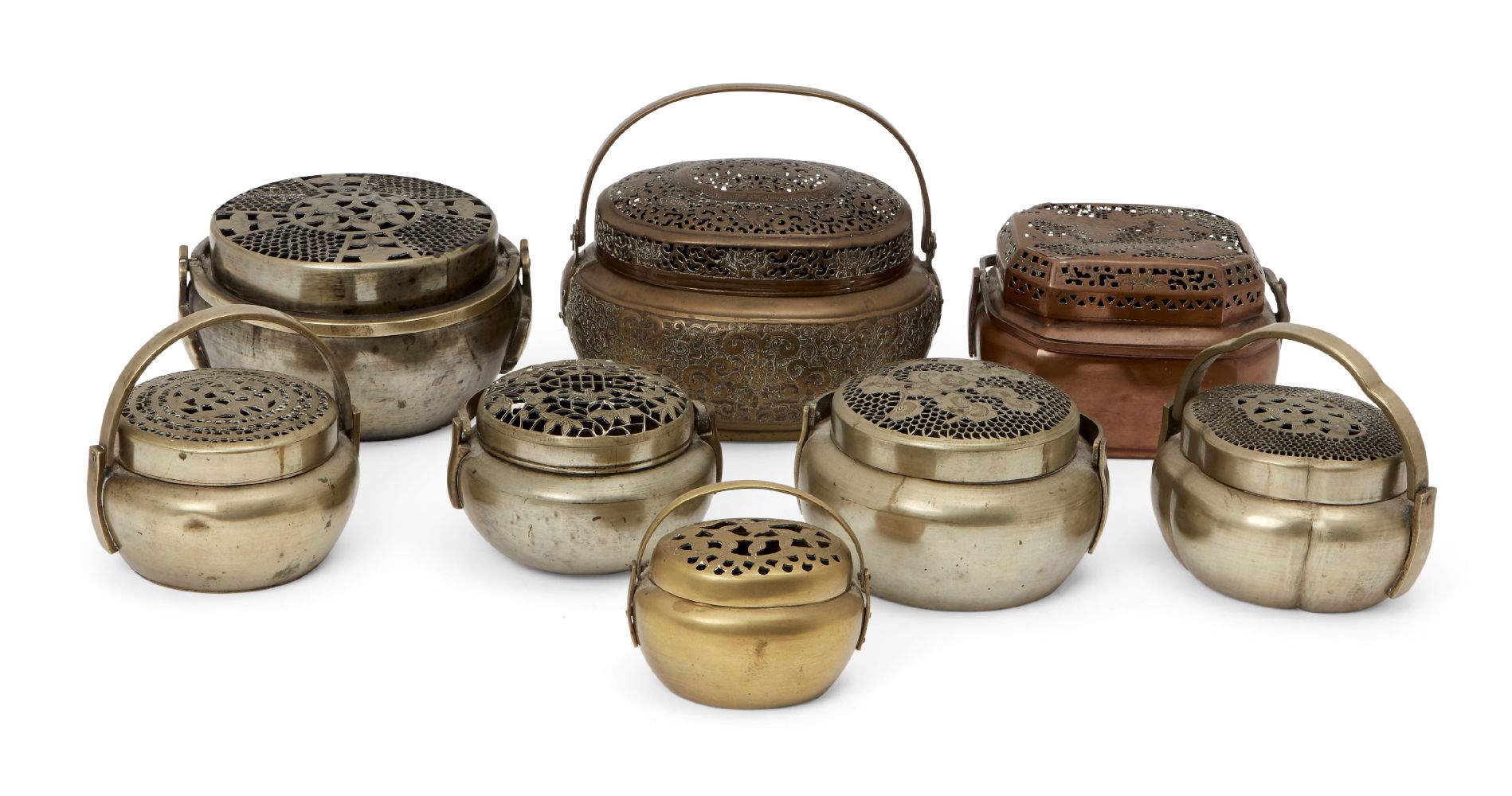 Eight Chinese metal handwarmers, 19th century - early 20th century, each with pierced floral