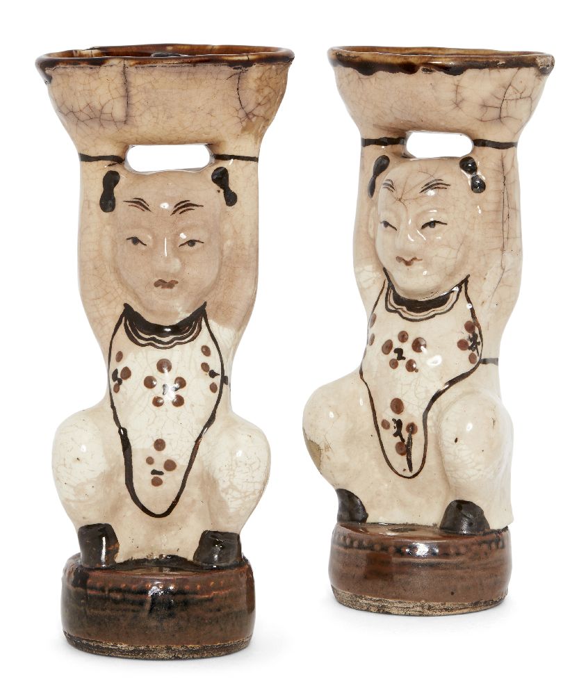 A pair of Chinese pottery Cizhou figural incense holders, Ming dynasty, moulded as boys seated on
