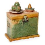 A Chinese pottery sancai-glazed miniature chest, Ming dynasty, surmounted with offerings of food,