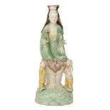 A Chinese biscuit porcelain sancai Guanyin figure group, Kangxi period, modelled as Guanyin seated