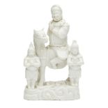 A Chinese blanc de chine figure group, Kangxi period, modelled as Guandi on horseback beside two