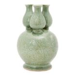 A Chinese porcelain celadon three-section vase, Republic period, moulded with flowering meandering