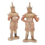 A pair of large Chinese pottery standing figures of guardians, Tang dynasty, each with detailed