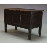 An oak coffer, mid 17th century, the hinged two plank lid enclosing storage space and candle holder,