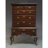 A George III oak chest on stand, the moulded cornice above two short and three long graduated