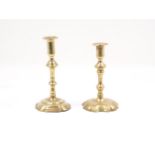 A brass candlestick, 18th century, with knopped stem, cylindrical flared socket, to a stylised foot,