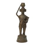 A Nigerian bronze maternity figure, 20th century, modelled standing cradling a child and carrying