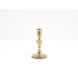 A French brass candlestick, 17th century, designed with acorn knop, cylindrical flared socket, wax