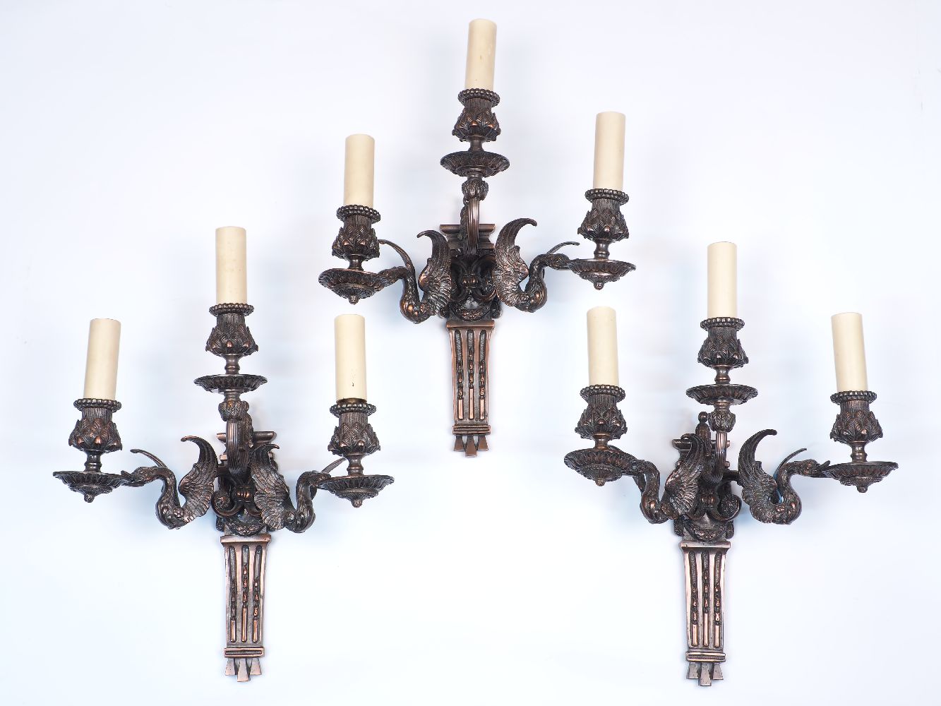 A group of three 19th century copper three branch wall lights, each with two lights raised on