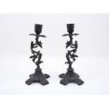 A pair of bronze coloured candlesticks, early 20th century, each designed with vine form stems,