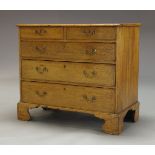 A George III oak chest, with two short over three long graduated drawers, raised on shaped bracket