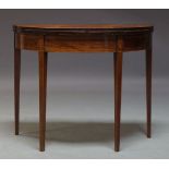 A George III mahogany demi-lune tea table, with fold over top, above frieze inlaid with paterae,