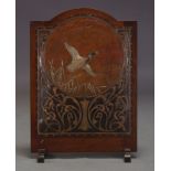 An Edwardian mahogany fire screen, with embossed leather panel depicting a duck in flight with Art