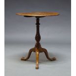 A George III style mahogany tilt top occasional table, the circular top on spiral turned column to