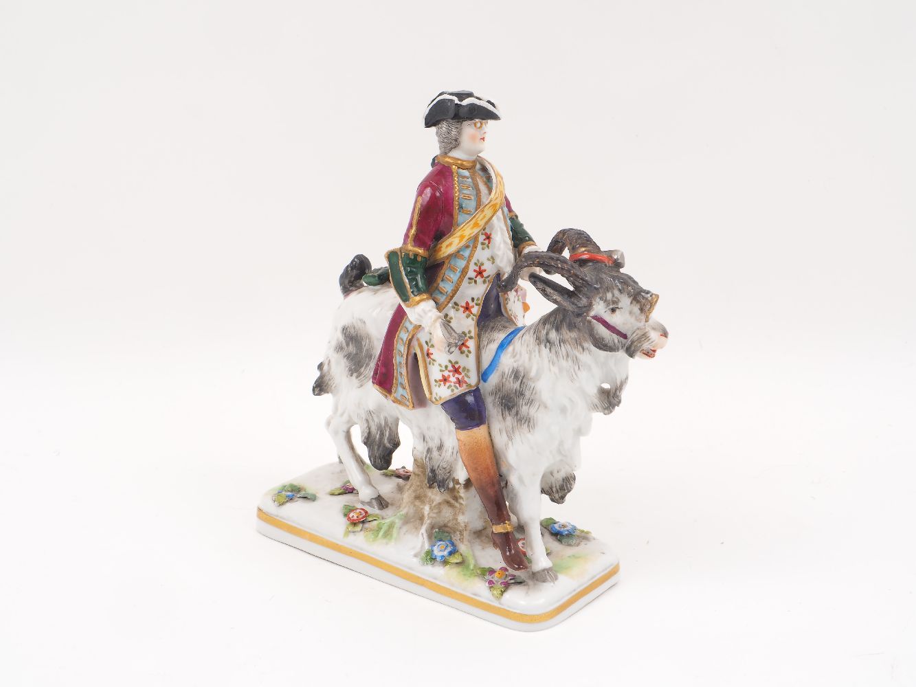 A Capodimonte porcelain figure, 19th century, designed a gentleman riding a goat, to a florally