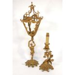 A gilt metal lamp, in the form of a female figure holding aloft a lantern, she standing on a foliate