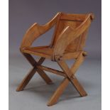 An oak Glastonbury armchair, early 20th Century, the square panelled back with shaped arms, on x-