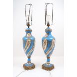 A pair of Sevres style porcelain lamps of baluster form, with floral form designs to a blue