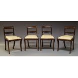 A set of four Regency mahogany bar back dining chairs, with central floral carved splat, above cream