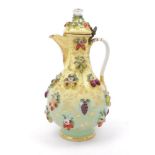 A Continental porcelain ewer, 19th century, with hinged lid, overall applied with fruit, flowers and