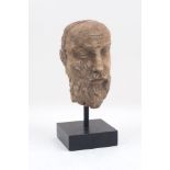 A carved stone bust, 17th century style, designed after a Greek Philosopher, to an ebonised stand,