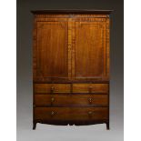 A Regency mahogany linen press, the moulded cornice with ebonised roundels above two ebony strung