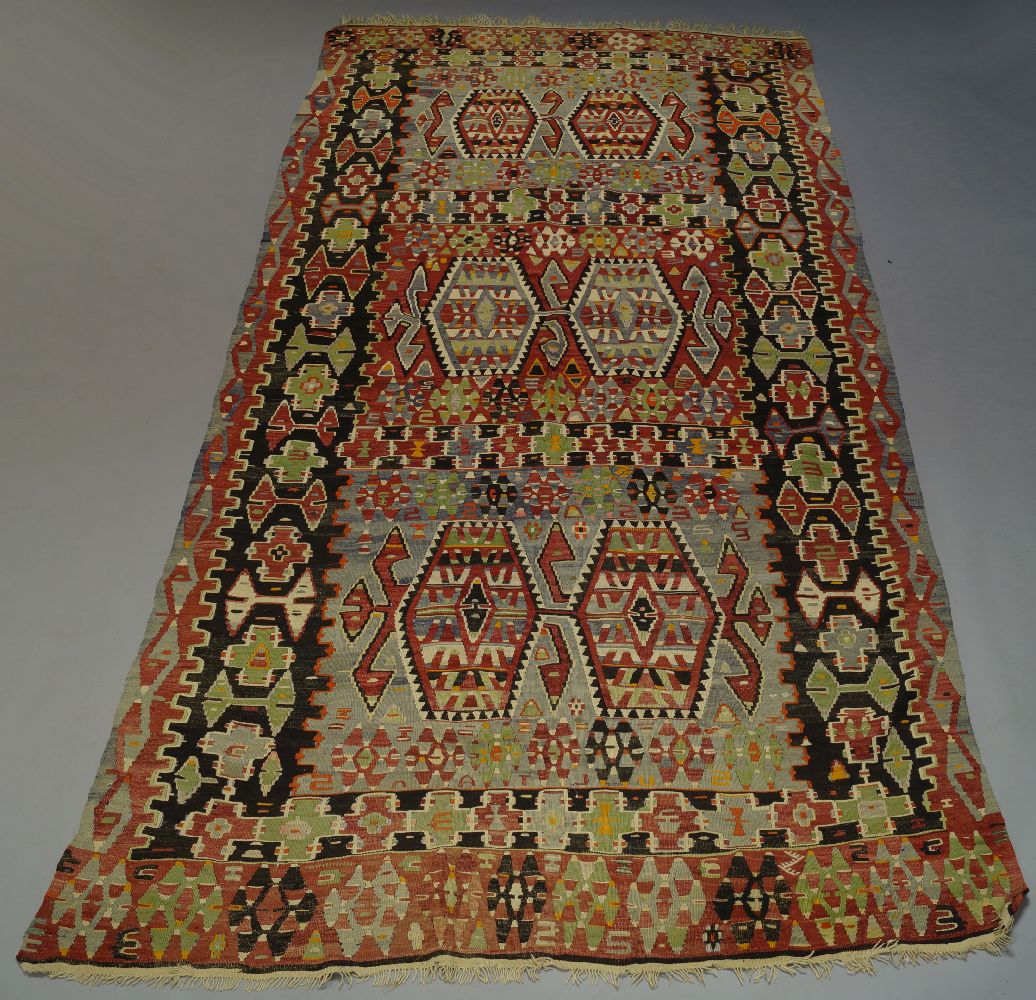 An Anatolian Kilim, the polychrome field with six hexagonal lozenge medallions and all over