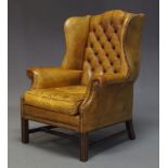 A George III style Wingback armchair, mid 20th Century, with green button back upholstery and