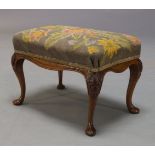 A needlework foot stool, late 19th, early 20th Century, with floral needlework seat on carved