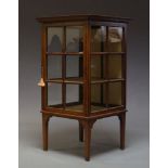 An Edwardian mahogany display cabinet, the square top with central inlaid patera, above glazed