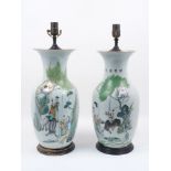 A pair of early 20th century Chinese vases, each of baluster form with wooden stepped bases,