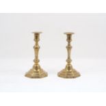 A pair of French brass candlesticks, 18th century, designed with hexagonal bodies, the tapering stem