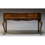 A Regency and later mahogany breakfront serving table, with three frieze drawers above shaped and
