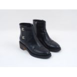 A pair of Chanel leather ankle boots, designed in black, with distinctive Chanel logo white metal