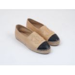 A pair of Chanel lambskin espadrilles, designed in beige and black, with distinctive Chanel logo,