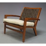 A modern teak armchair, of recent manufacture, with woven leather backrest above seat with loose