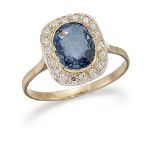 A sapphire and diamond cluster ring, the oval sapphire single stone in collet-set mount within a