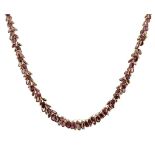 A garnet leaf cluster necklace, designed as an overlapping series of graduating collet-set garnets