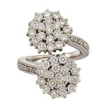 A diamond cluster ring, of crossover design, the brilliant-cut diamond twin clusters to brilliant-