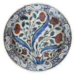 An Iznik pottery dish, Ottoman Turkey, circa 1590, with sloping rim on short foot, the white