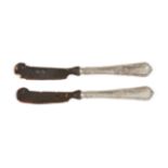 A pair of horn butter knives, early 20th century, with horn blades and silver handles stamped '